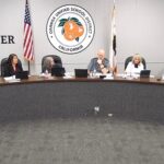 Orange Unified School District Board of Education members seated at the dais during the October 15, 2026 board meeting, with the district seal and a Golden Bell Awards banner behind them.