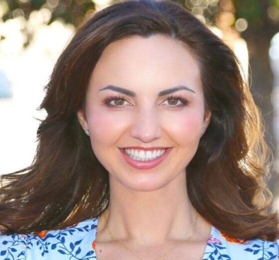 Orange City Council candidate Brandy Romero smiling outdoors in a blue floral top.