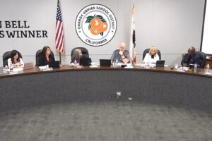 Orange Unified School District Board of Education members seated at the dais during the October 15, 2026 board meeting, with the district seal and a Golden Bell Awards banner behind them.