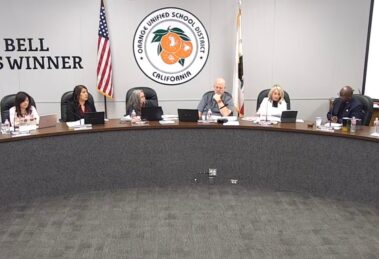 Orange Unified School District Board of Education members seated at the dais during the October 15, 2026 board meeting, with the district seal and a Golden Bell Awards banner behind them.